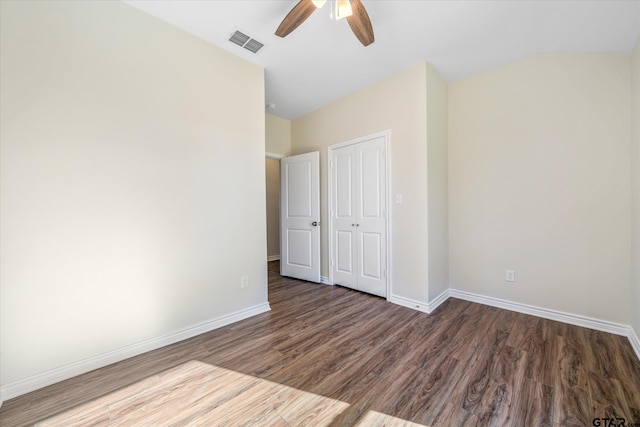 unfurnished bedroom featuring a closet, dark hardwood / wood-style floors, and ceiling fan