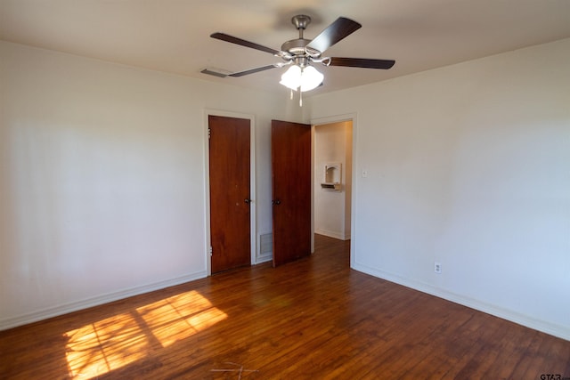 unfurnished room featuring baseboards, visible vents, and wood finished floors