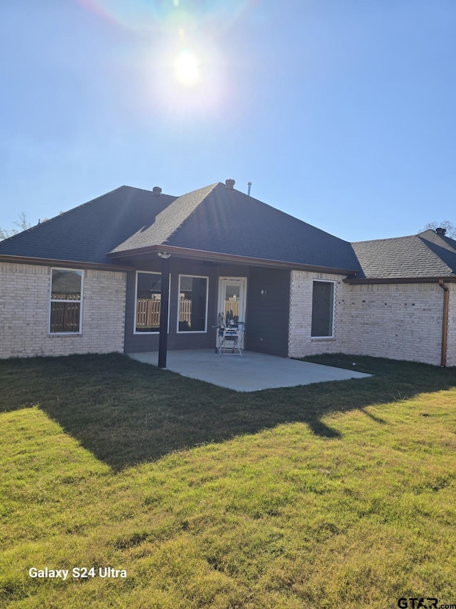 back of property with a patio area and a lawn