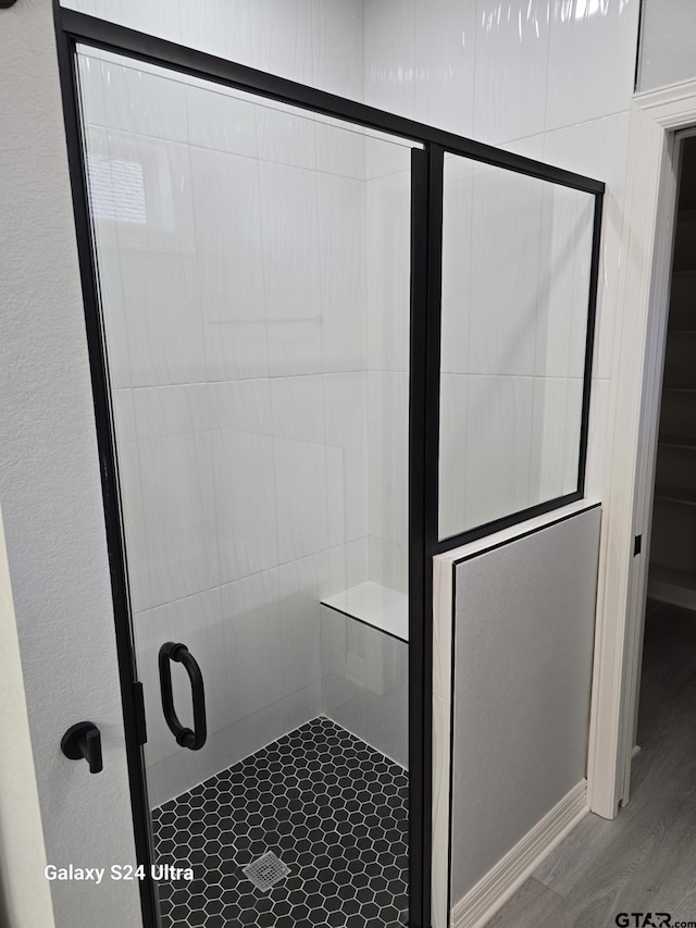 bathroom featuring hardwood / wood-style floors and walk in shower