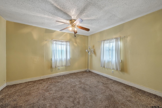 carpeted spare room featuring ceiling fan and a textured ceiling