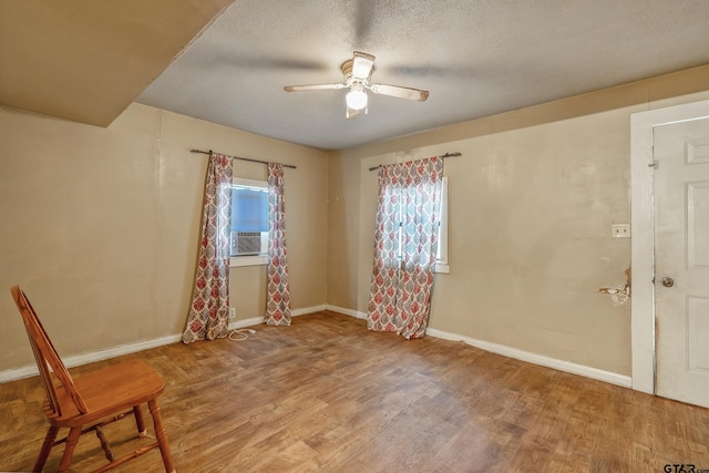 empty room featuring a textured ceiling, hardwood / wood-style flooring, and ceiling fan