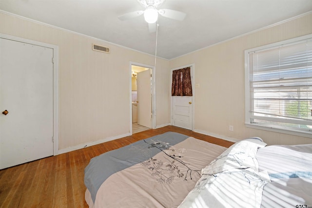 bedroom with ceiling fan, ensuite bathroom, ornamental molding, and light wood-type flooring