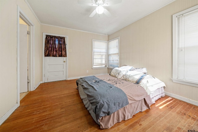 bedroom with wood-type flooring, ceiling fan, and crown molding