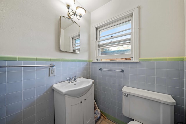 bathroom featuring vanity, tile walls, and toilet