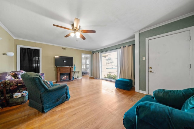 living room featuring ceiling fan, wood-type flooring, and ornamental molding