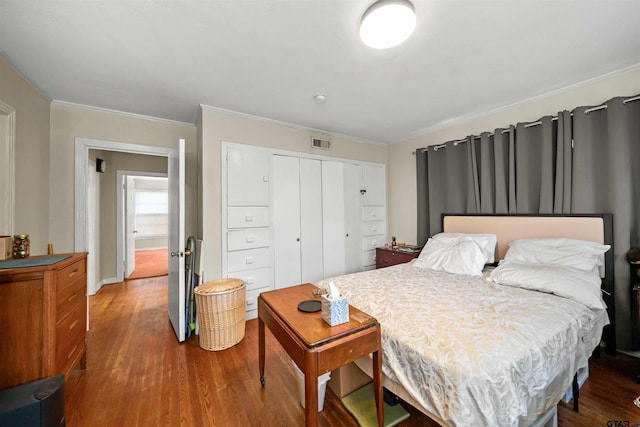 bedroom featuring crown molding, a closet, and hardwood / wood-style flooring