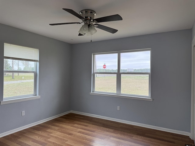 unfurnished room featuring a ceiling fan, baseboards, and wood finished floors