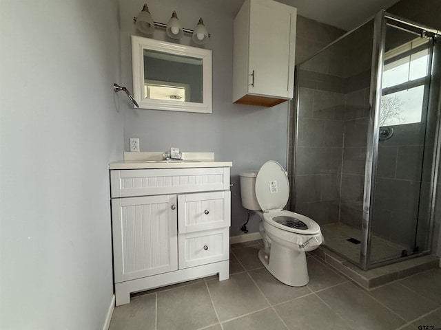 full bath featuring toilet, a stall shower, vanity, tile patterned flooring, and baseboards