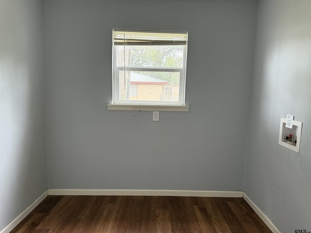 spare room featuring dark wood-type flooring and baseboards