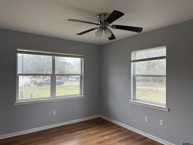 unfurnished room with ceiling fan, baseboards, and wood finished floors