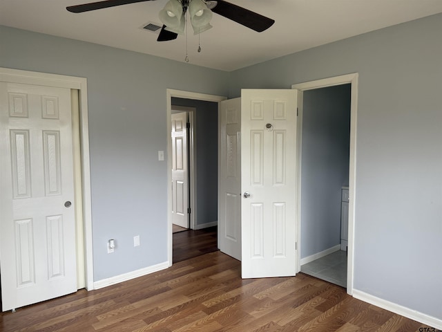 unfurnished bedroom featuring a ceiling fan, visible vents, baseboards, and wood finished floors