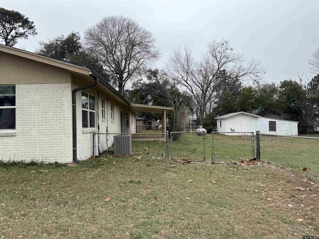 view of yard with central AC unit, fence, and a gate