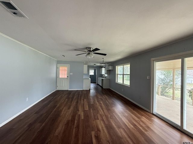 unfurnished living room with baseboards, visible vents, a ceiling fan, dark wood-style floors, and ornamental molding