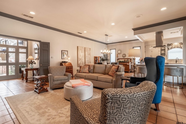 living room featuring light tile patterned flooring, ornamental molding, sink, and a notable chandelier