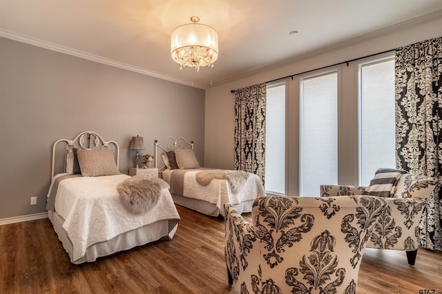 bedroom with hardwood / wood-style flooring, crown molding, and a notable chandelier