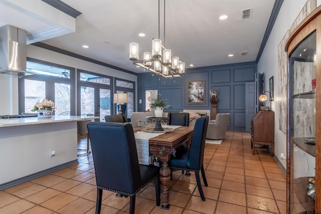 tiled dining area featuring ornamental molding and a chandelier