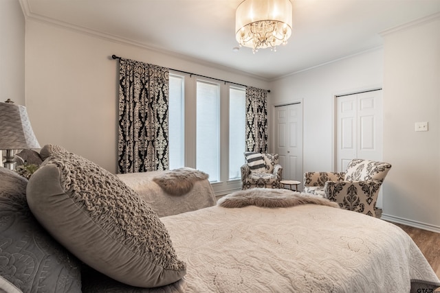 bedroom featuring crown molding, hardwood / wood-style flooring, and an inviting chandelier