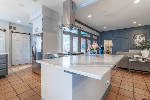 kitchen with white cabinetry, island exhaust hood, light tile patterned floors, stainless steel fridge with ice dispenser, and a barn door