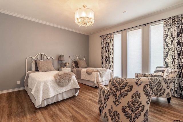 bedroom featuring an inviting chandelier, crown molding, and hardwood / wood-style floors