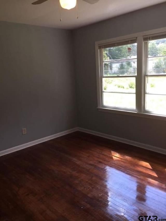 1108 Raney Dr, Longview, TX 75602 - unfurnished room featuring plenty of natural light, a ceiling fan, dark wood finished floors, and baseboards
