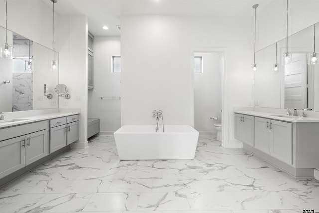 4645 Cascades Blvd, Tyler, TX 75709 - full bath with toilet, recessed lighting, marble finish flooring, a freestanding tub, and two vanities