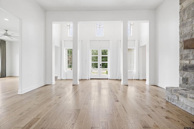 4645 Cascades Blvd, Tyler, TX 75709 - unfurnished living room featuring light wood finished floors, a towering ceiling, a ceiling fan, and baseboards