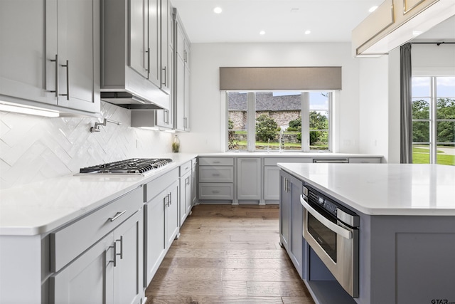4645 Cascades Blvd, Tyler, TX 75709 - kitchen with stainless steel appliances, gray cabinetry, backsplash, light countertops, and recessed lighting
