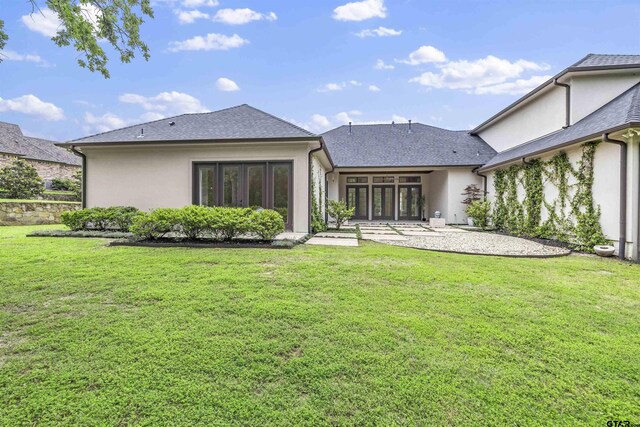4645 Cascades Blvd, Tyler, TX 75709 - rear view of house with stucco siding, a yard, french doors, and roof with shingles
