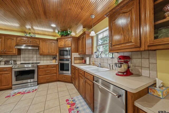 13094 Fm 2010, Chandler, TX 75758 - kitchen with stainless steel appliances, a sink, under cabinet range hood, brown cabinets, and light countertops