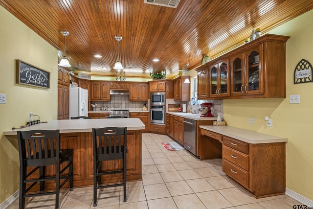 13094 Fm 2010, Chandler, TX 75758 - kitchen with stainless steel appliances, a peninsula, glass insert cabinets, backsplash, and under cabinet range hood