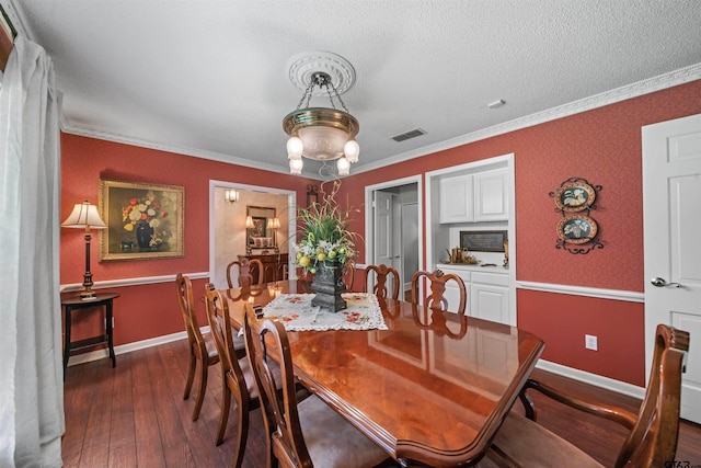 dining area with a textured ceiling, dark hardwood / wood-style floors, and crown molding