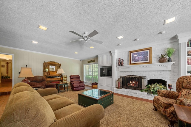 carpeted living room with ceiling fan, crown molding, a textured ceiling, and a brick fireplace