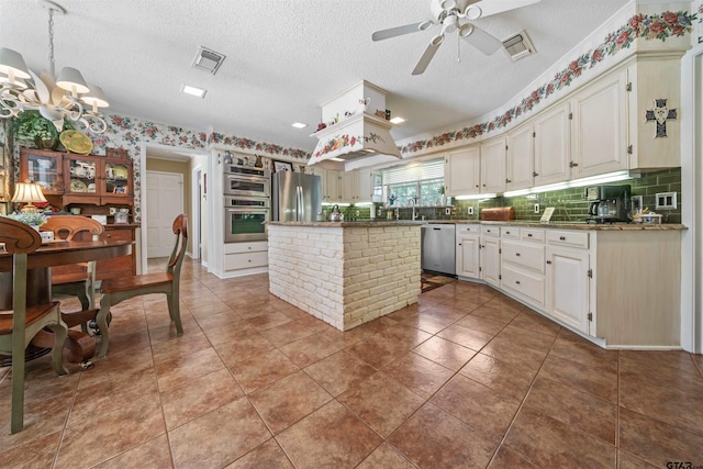 kitchen with appliances with stainless steel finishes, a center island, and dark tile patterned floors