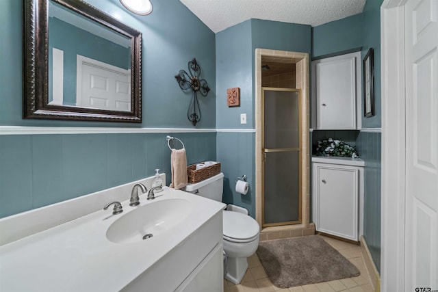 bathroom with tile patterned flooring, a textured ceiling, and walk in shower