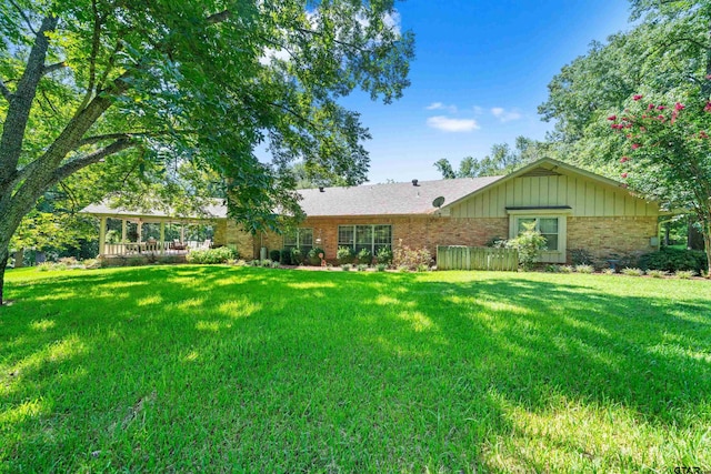 rear view of house featuring a yard