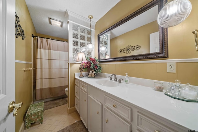 bathroom with walk in shower, tile patterned flooring, a textured ceiling, toilet, and vanity