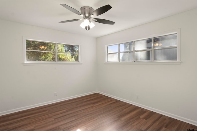 spare room with a ceiling fan, dark wood finished floors, and baseboards