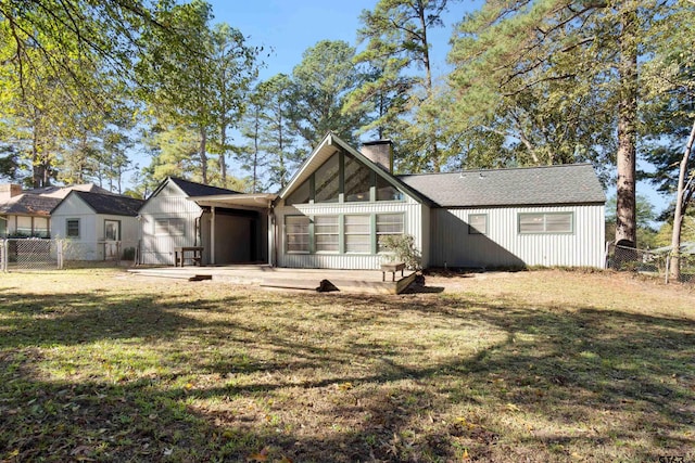 view of front of home with fence, a chimney, and a front lawn