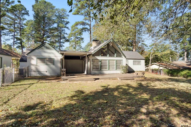 rear view of property with fence, a deck, and a yard