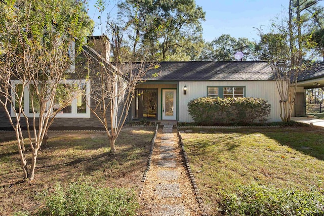 view of front of home featuring roof with shingles and a front lawn