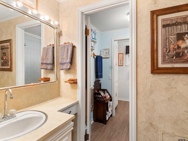 bathroom with hardwood / wood-style flooring, vanity, and crown molding