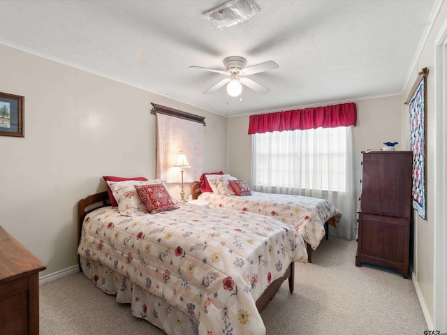 bedroom featuring a textured ceiling, crown molding, light colored carpet, and ceiling fan