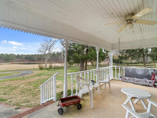 view of patio / terrace featuring covered porch, a rural view, and ceiling fan