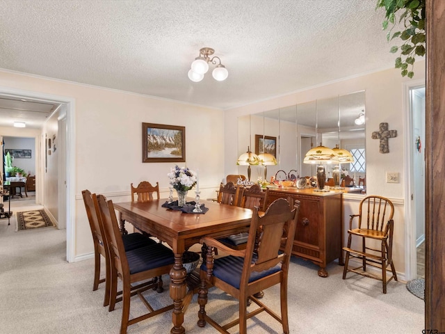 dining space with light carpet, crown molding, and a textured ceiling