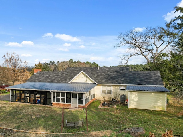 back of property featuring central AC, a lawn, and a sunroom