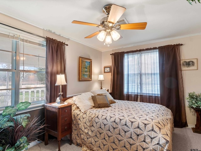 bedroom featuring multiple windows, crown molding, light colored carpet, and ceiling fan