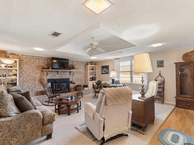 living room with ceiling fan, brick wall, a textured ceiling, and light hardwood / wood-style flooring