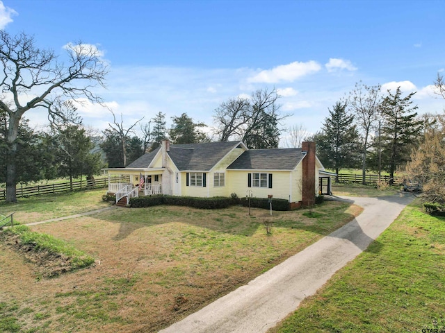 view of front of property with a rural view, a front lawn, and a porch