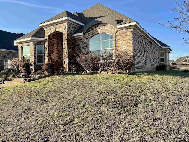 french country home with a front lawn and brick siding